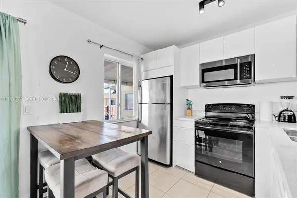 a kitchen with stainless steel appliances a stove a refrigerator and a microwave