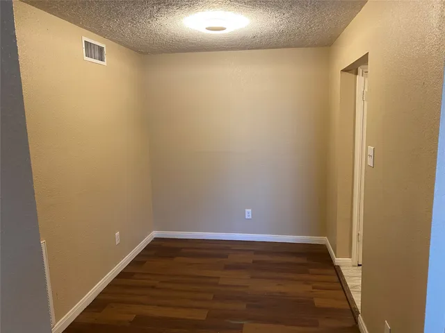 a kitchen with granite countertop white cabinets and refrigerator