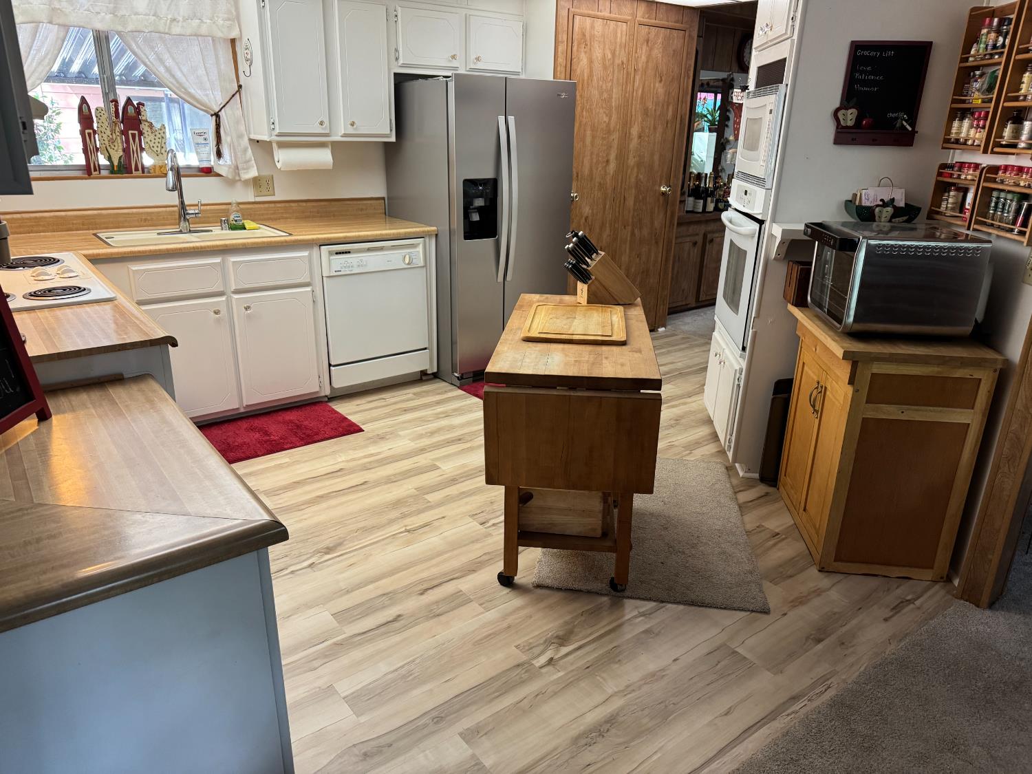 4420 Pleasant Valley Road, Unit 130 Diamond Springs, CA 95619 - Photo 13 of 39 a kitchen with stainless steel appliances kitchen island granite countertop a refrigerator stove microwave and sink