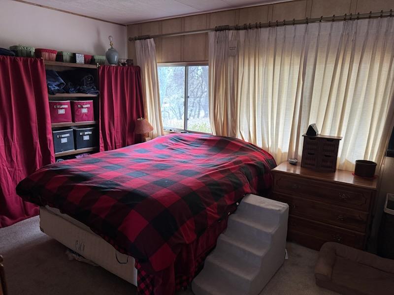 4420 Pleasant Valley Road, Unit 130 Diamond Springs, CA 95619 - Photo 24 of 39 a bed sitting in a bedroom next to a window and a flat screen tv