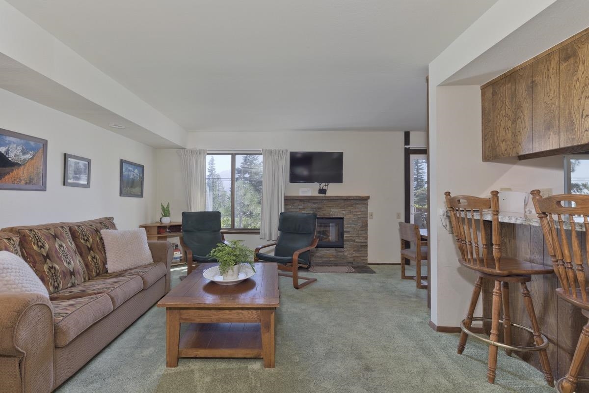 25 Lee Road, Unit 111 Mammoth Lakes, CA 93546 - Photo 1 of 32 a living room with furniture a fireplace and a flat screen tv