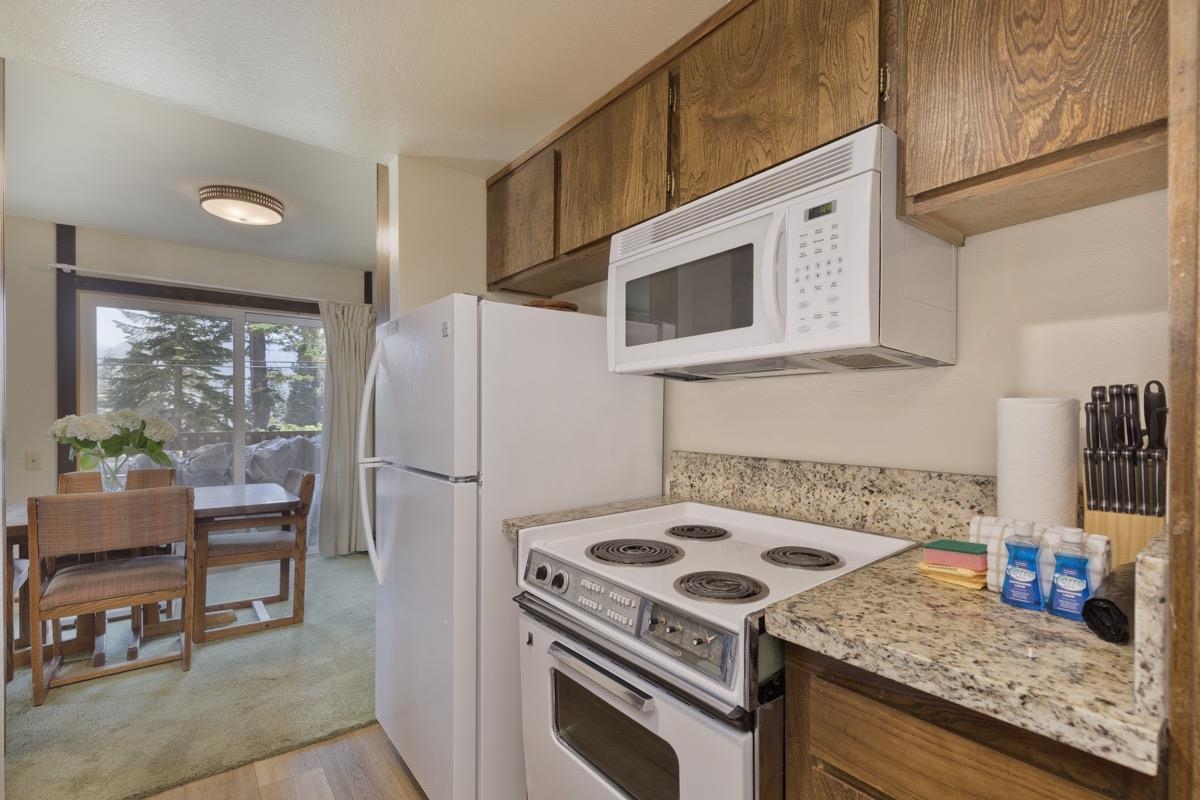 25 Lee Road, Unit 111 Mammoth Lakes, CA 93546 - Photo 15 of 32 a kitchen with granite countertop a sink a stove and refrigerator
