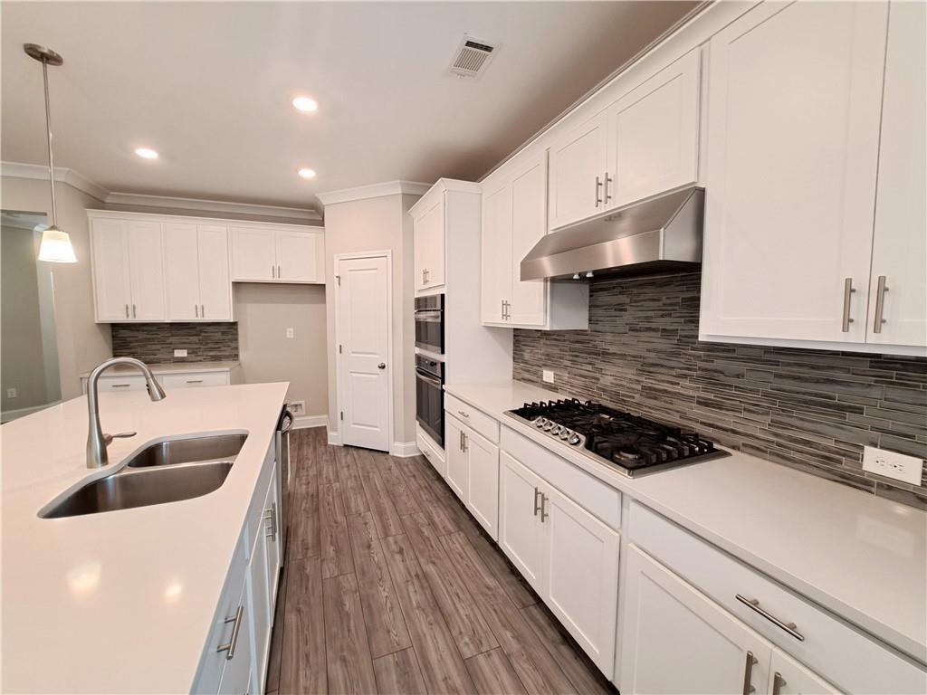 637 Stan Hope Lane Suwanee, GA 30024 - Photo 15 of 44 a kitchen with stainless steel appliances kitchen island granite countertop a sink stove and refrigerator