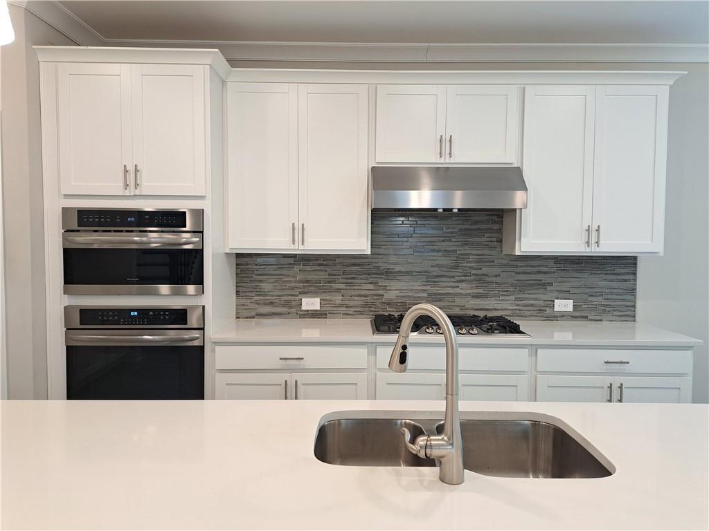 637 Stan Hope Lane Suwanee, GA 30024 - Photo 16 of 44 a kitchen with stainless steel appliances a sink stove and cabinets