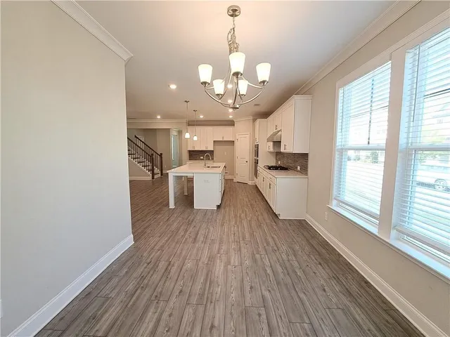 a view of a kitchen with wooden floor and stainless steel appliances