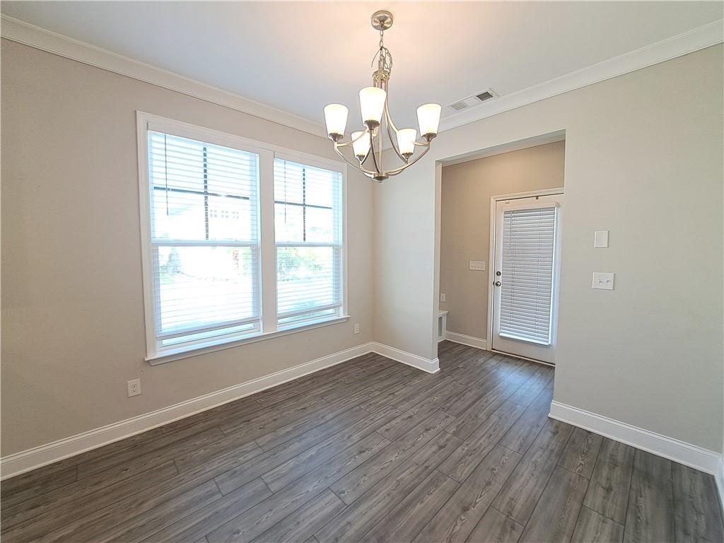 637 Stan Hope Lane Suwanee, GA 30024 - Photo 19 of 44 an empty room with wooden floor chandelier and windows