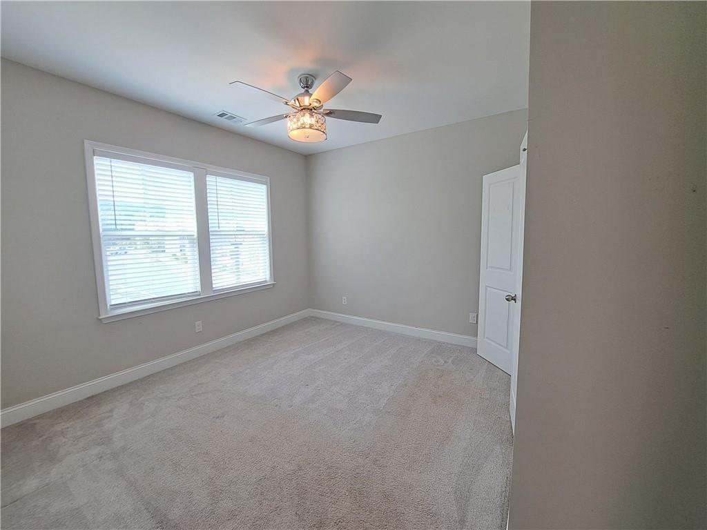 637 Stan Hope Lane Suwanee, GA 30024 - Photo 27 of 44 an empty room with windows and chandelier fan