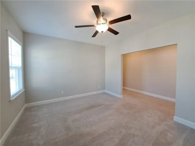 an empty room with a window and a fan