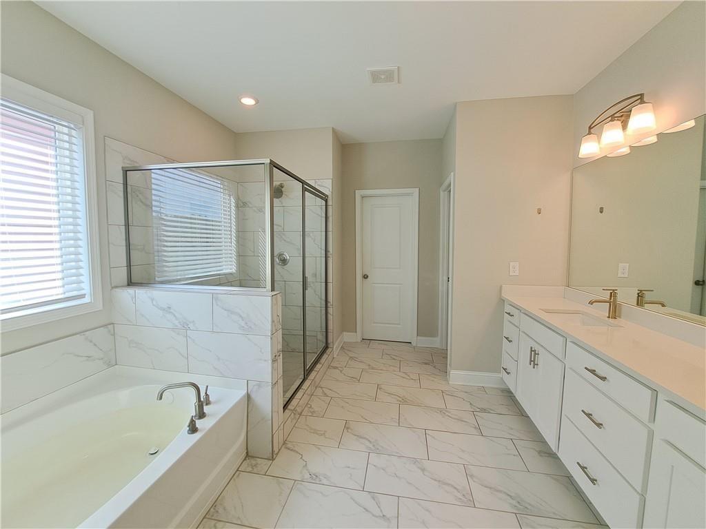 637 Stan Hope Lane Suwanee, GA 30024 - Photo 36 of 44 a spacious bathroom with a tub sink shower and mirror