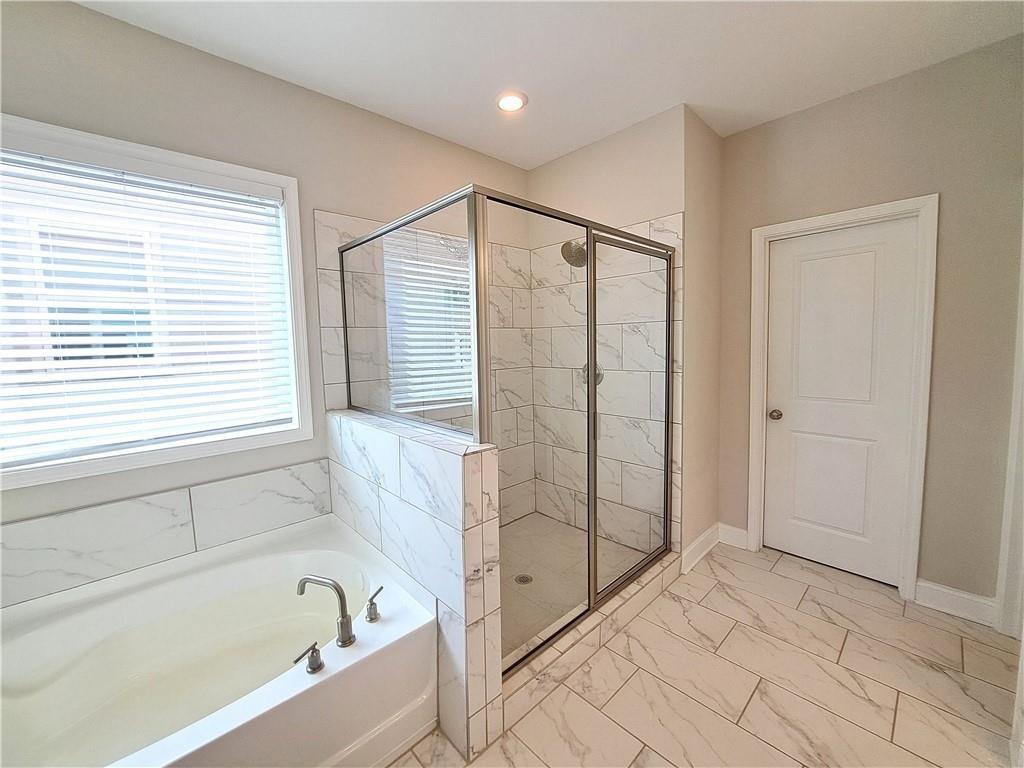 637 Stan Hope Lane Suwanee, GA 30024 - Photo 39 of 44 a bathroom with a bathtub and a shower