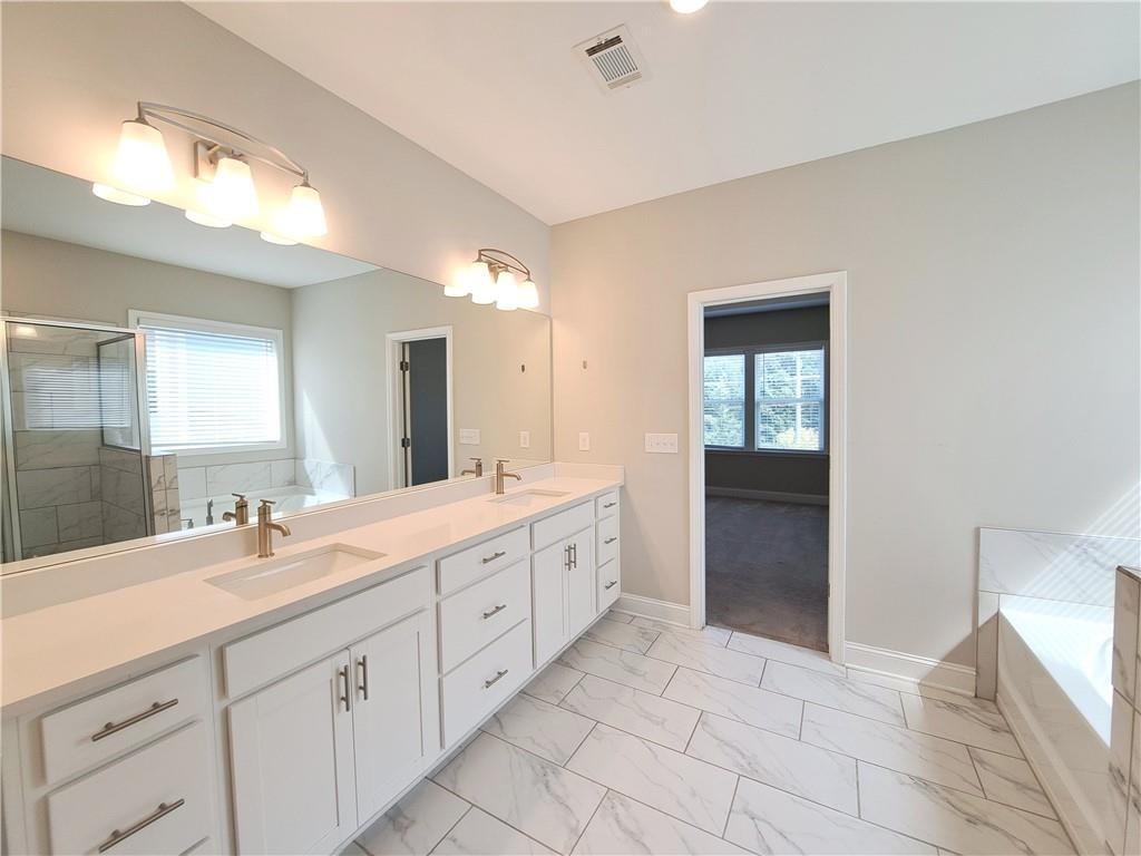 637 Stan Hope Lane Suwanee, GA 30024 - Photo 40 of 44 a spacious bathroom with a double vanity sink and a mirror