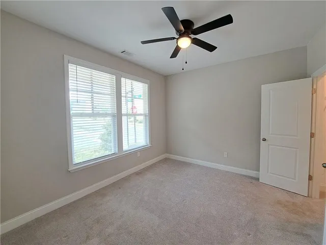 an empty room with a window and a fan