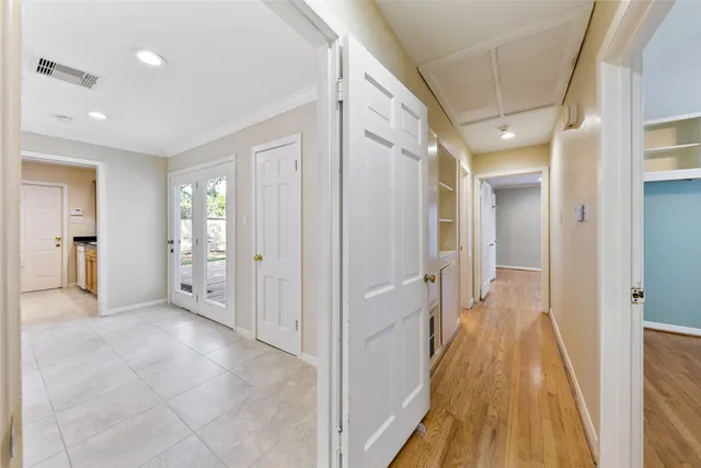 a view of a hallway with wooden floor and a bathroom