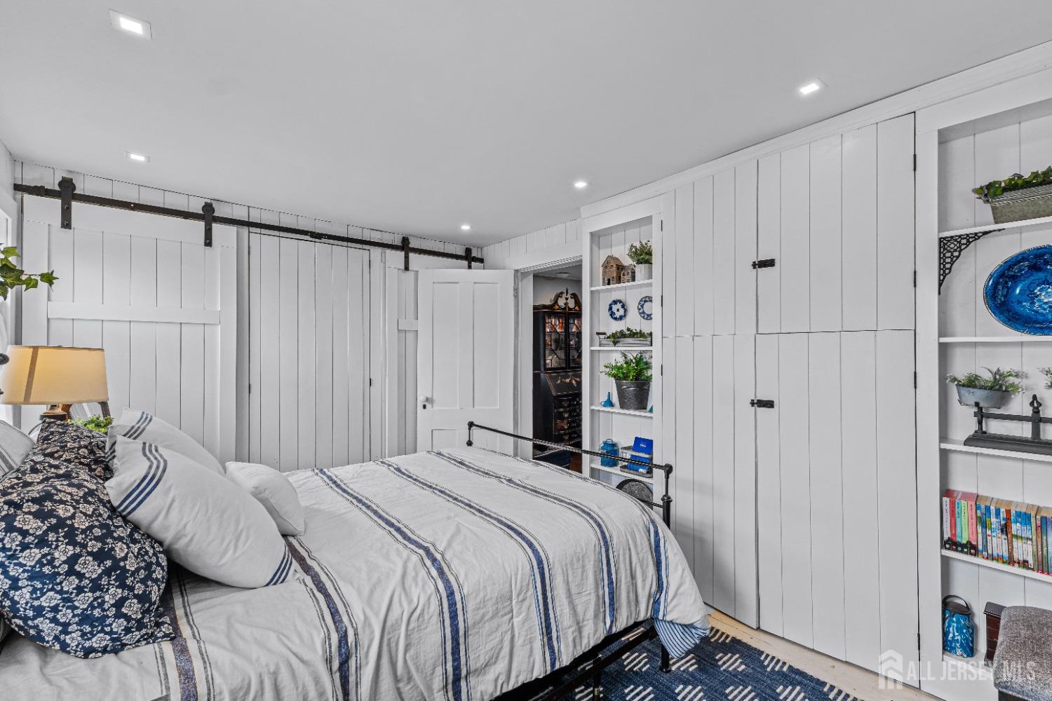 300 Blackpoint Road Neshanic Station, NJ 08853 - Photo 17 of 34 a bedroom with a bed a walk in closet and a book shelf