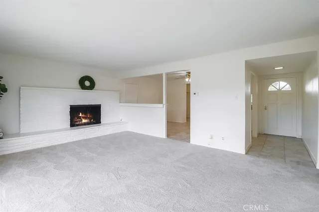 a view of an empty room with a fireplace and a window