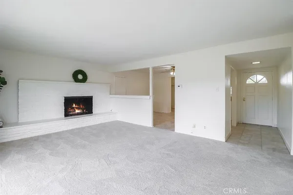 a view of an empty room with a fireplace and a window