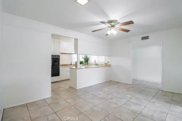 a kitchen with white cabinets and window