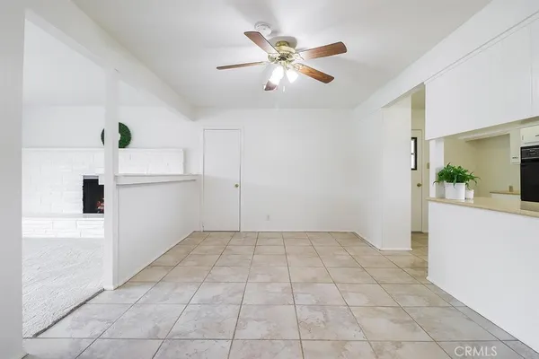 a view of a livingroom with wooden floor and a ceiling fan