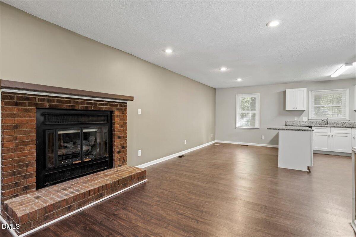 100 Brook Rock Lane Garner, NC 27529 - Photo 12 of 33 a view of kitchen with fireplace and wooden floor