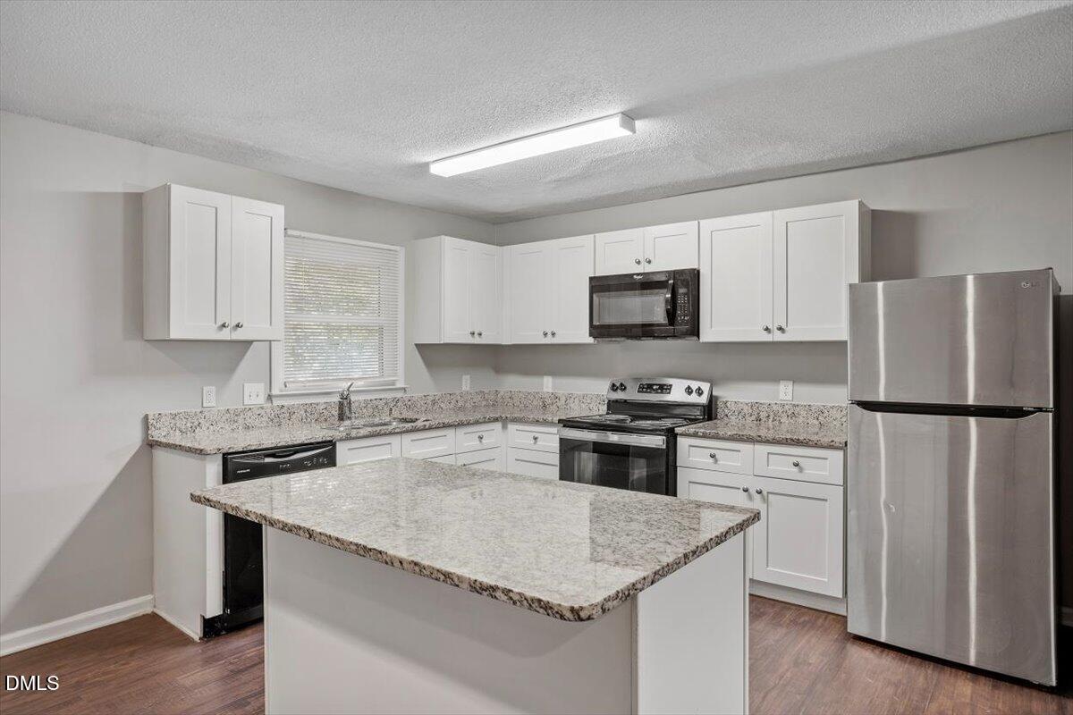 100 Brook Rock Lane Garner, NC 27529 - Photo 14 of 33 a kitchen with a stove a sink and a refrigerator
