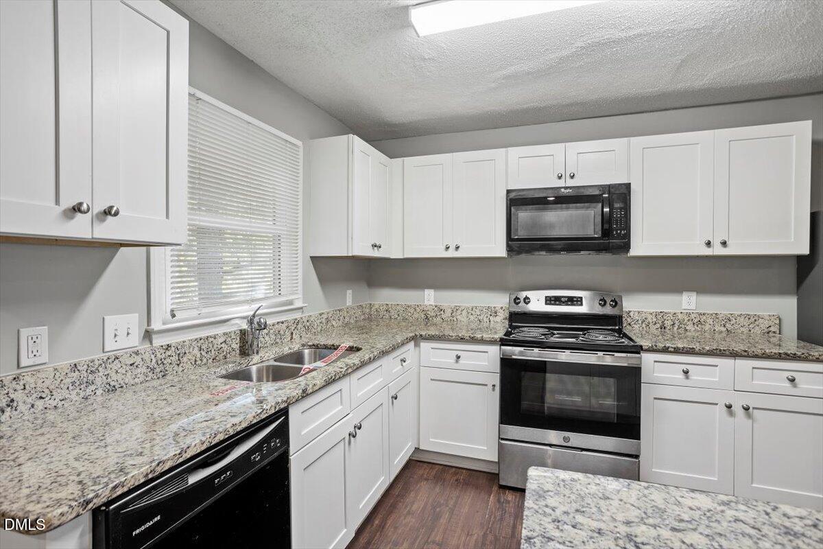 100 Brook Rock Lane Garner, NC 27529 - Photo 16 of 33 a kitchen with stainless steel appliances granite countertop a stove a sink and a microwave