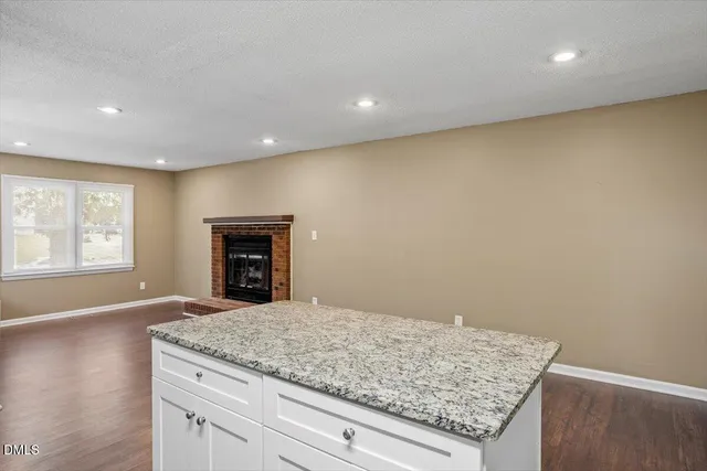 a view of kitchen with granite countertop cabinets and fireplace
