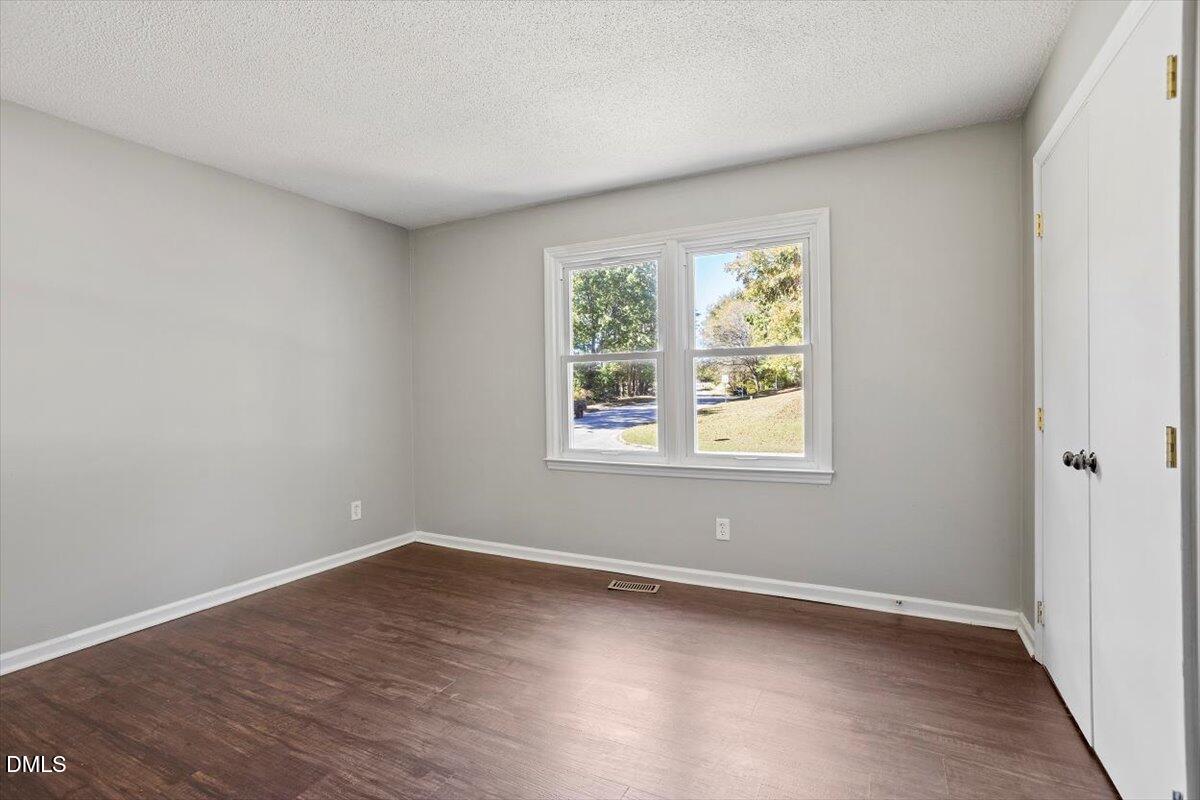 100 Brook Rock Lane Garner, NC 27529 - Photo 23 of 33 a view of an empty room with wooden floor and a window