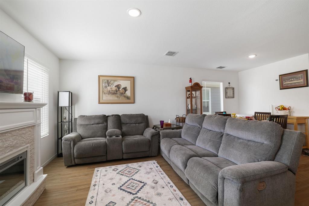 1445 Sterling Way Ferris, TX 75125 - Photo 2 of 17 Living room featuring light wood-type flooring, recessed lighting, and a stone fireplace