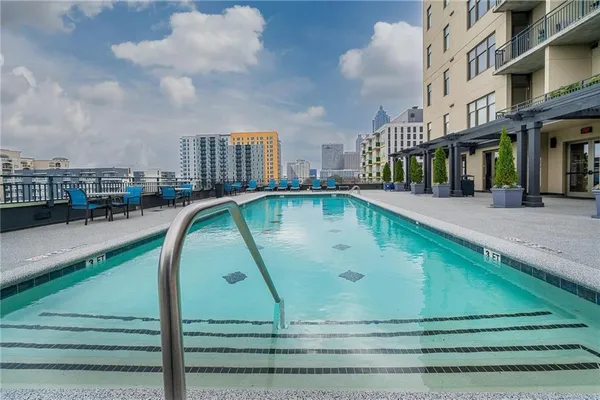 a view of swimming pool with outdoor seating and city view