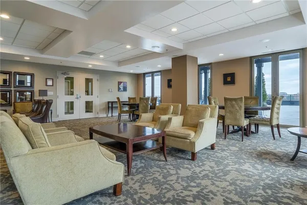 a kitchen with stainless steel appliances granite countertop a table chairs and a sink