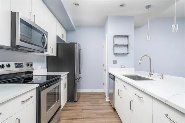 a kitchen with stainless steel appliances granite countertop a sink stove and refrigerator