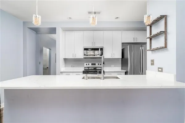 a kitchen with stainless steel appliances a refrigerator sink and stove