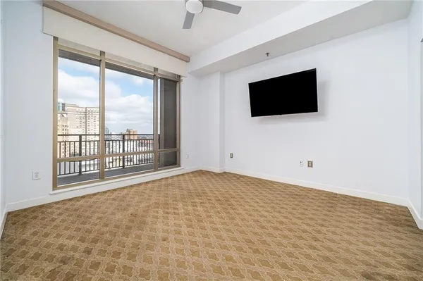a view of an empty room with a window and a flat screen tv