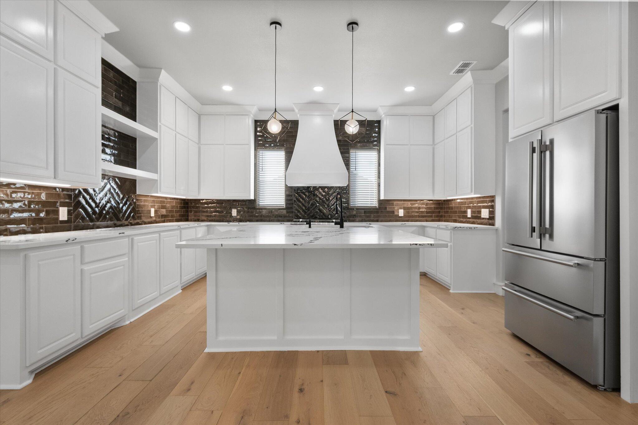 7516 57th Street Lubbock, TX 79407 - Photo 11 of 35 a kitchen with stainless steel appliances kitchen island a sink and a refrigerator
