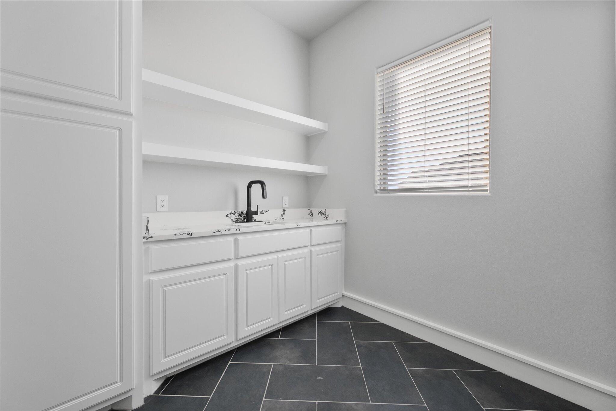 7516 57th Street Lubbock, TX 79407 - Photo 20 of 35 a room with a sink cabinets and window