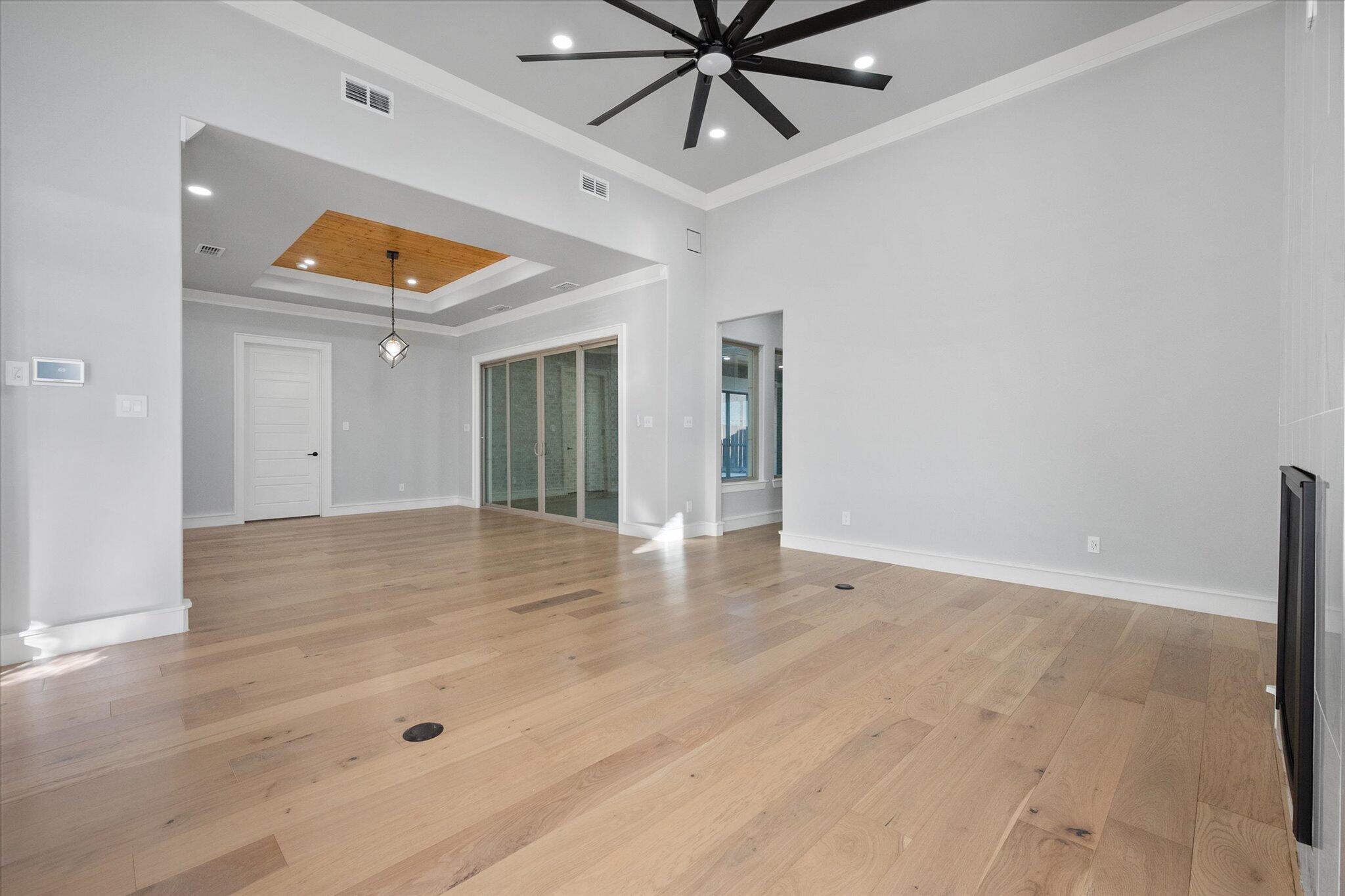 7516 57th Street Lubbock, TX 79407 - Photo 6 of 35 an empty room with wooden floor and door