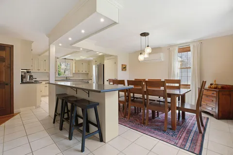 a large kitchen with a dining table chairs and large window