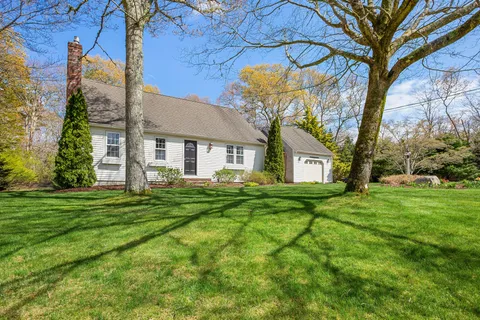 a view of a yard in front of a house with a large tree