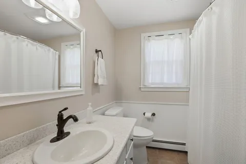 a bathroom with a sink a toilet and a mirror
