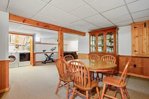 a dining room with furniture and a floor to ceiling window