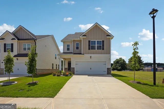 a front view of a house with a yard and potted plants