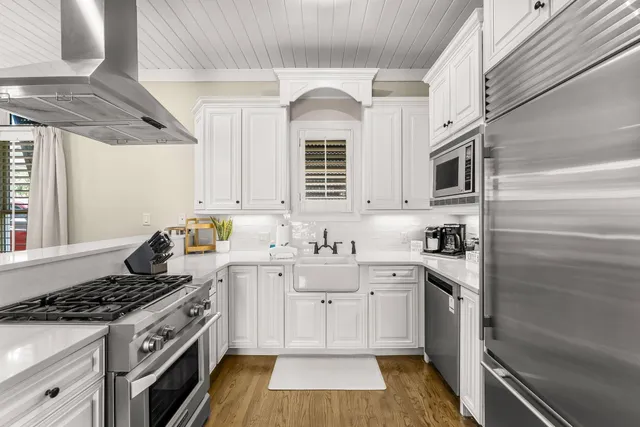 a kitchen with white cabinets and white appliances