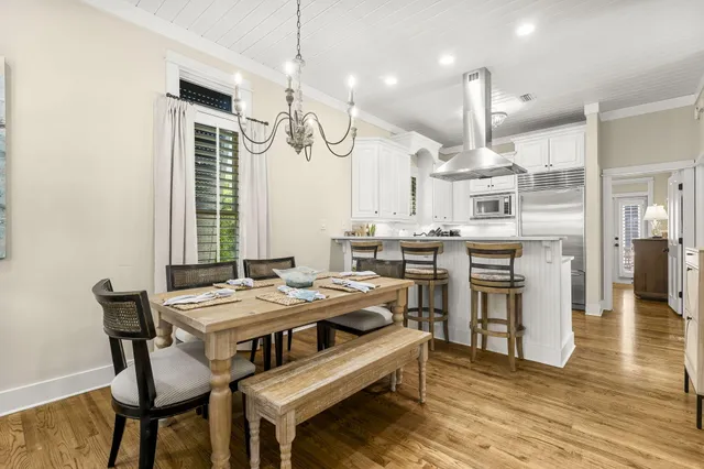 a kitchen with a dining table chairs sink and cabinets
