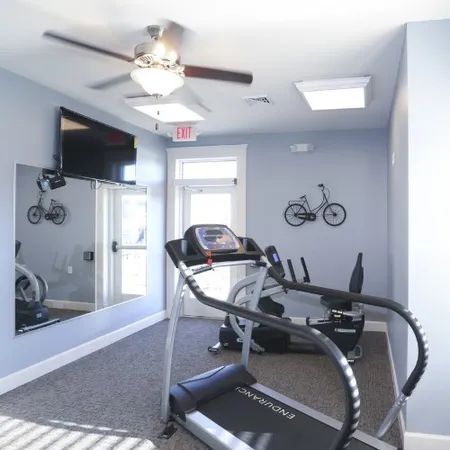 a room with gym equipment and a flat screen tv