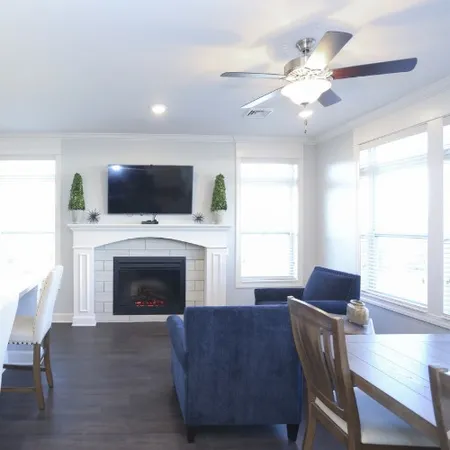 a living room with furniture a flat screen tv and a fireplace