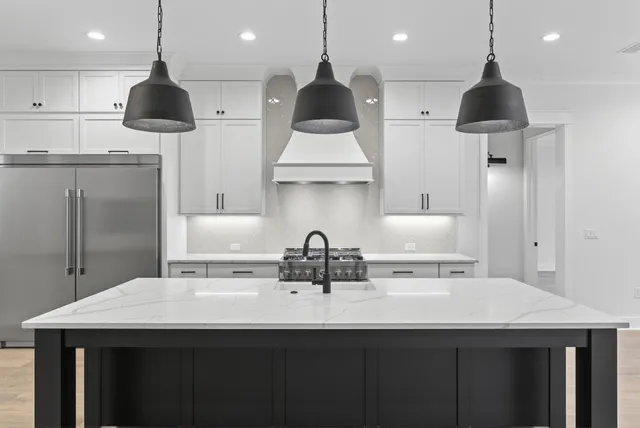 a kitchen with a sink a refrigerator and chairs
