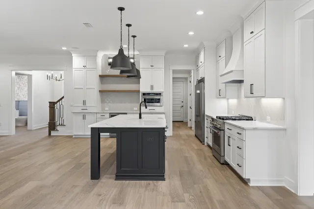 a large kitchen with stainless steel appliances granite countertop a stove and a refrigerator