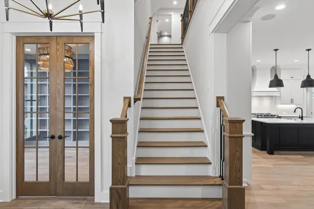 a view of a living room with wooden floor and stairs