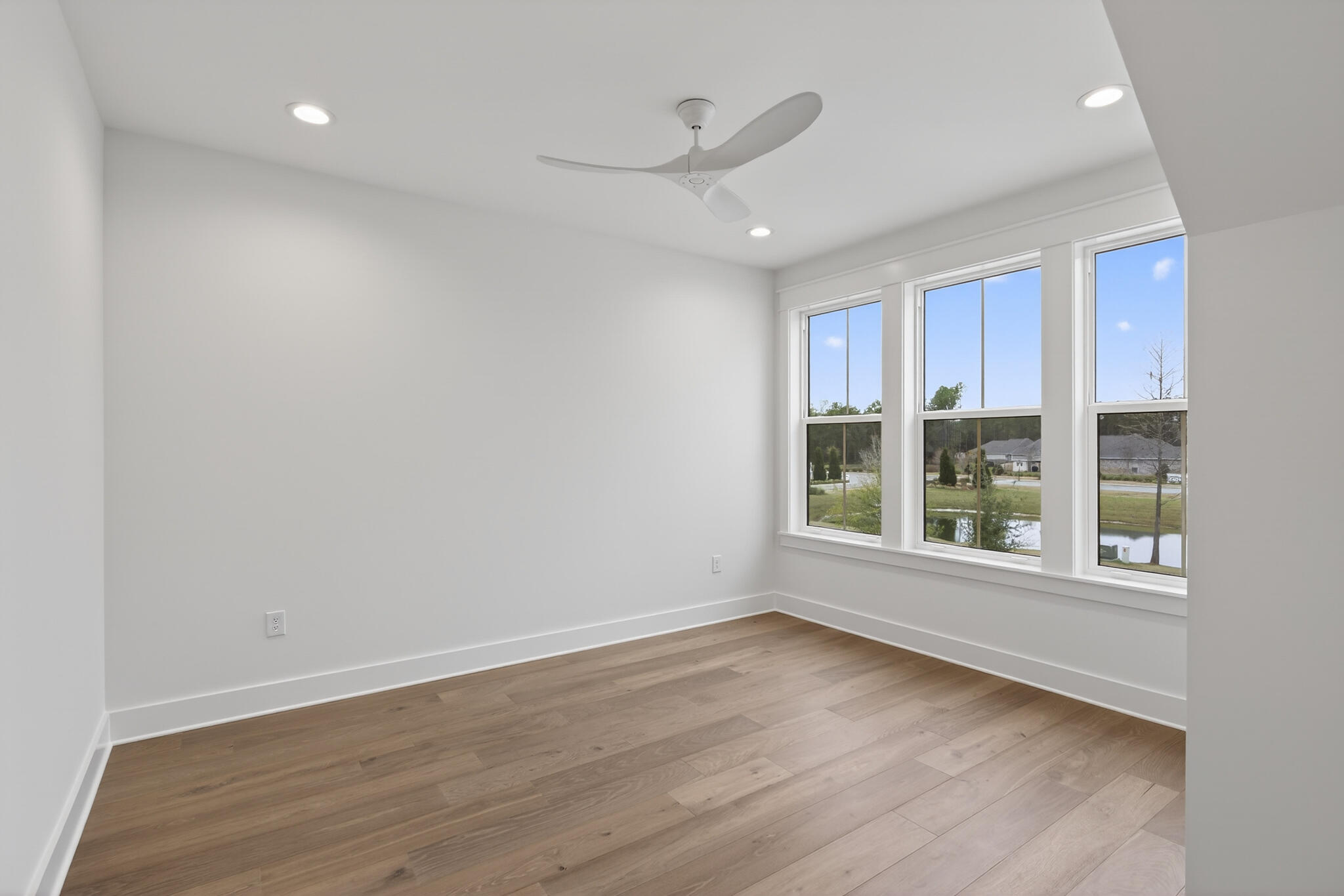453 Shimmer Circle Freeport, FL 32439 - Photo 35 of 38 an empty room with wooden floor and windows