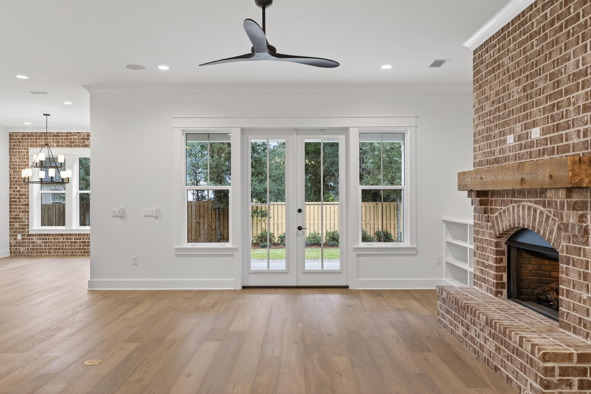 453 Shimmer Circle Freeport, FL 32439 - Photo 5 of 38 a view of an empty room with wooden floor and a fireplace